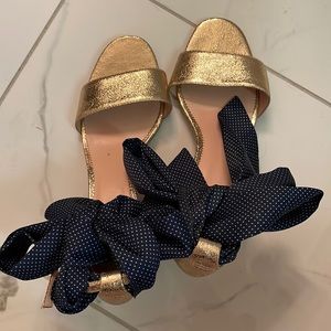 Gold Sandals with low square heel with a blue polka dot bow at the ankle